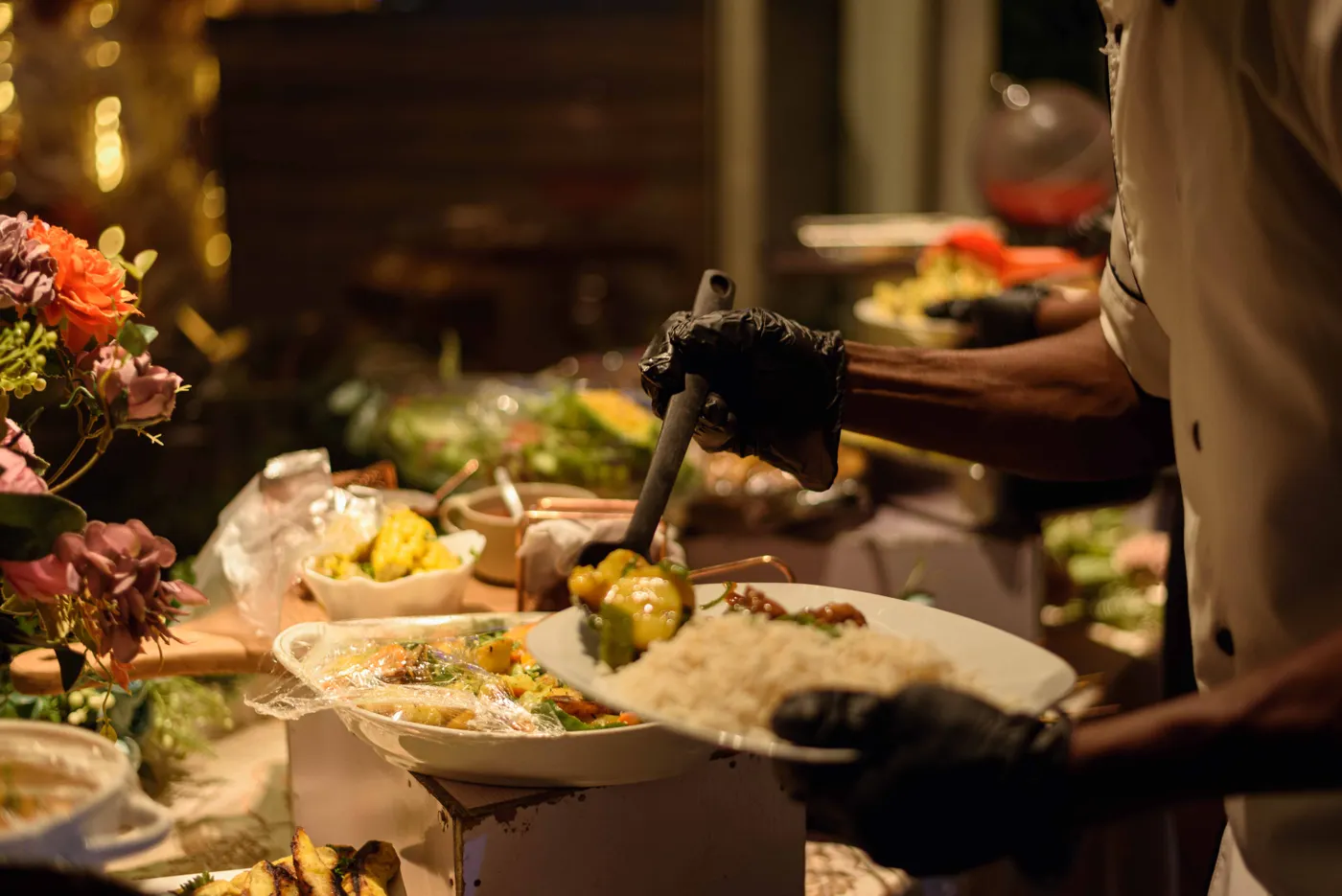 A caterer plating food at an event buffet
