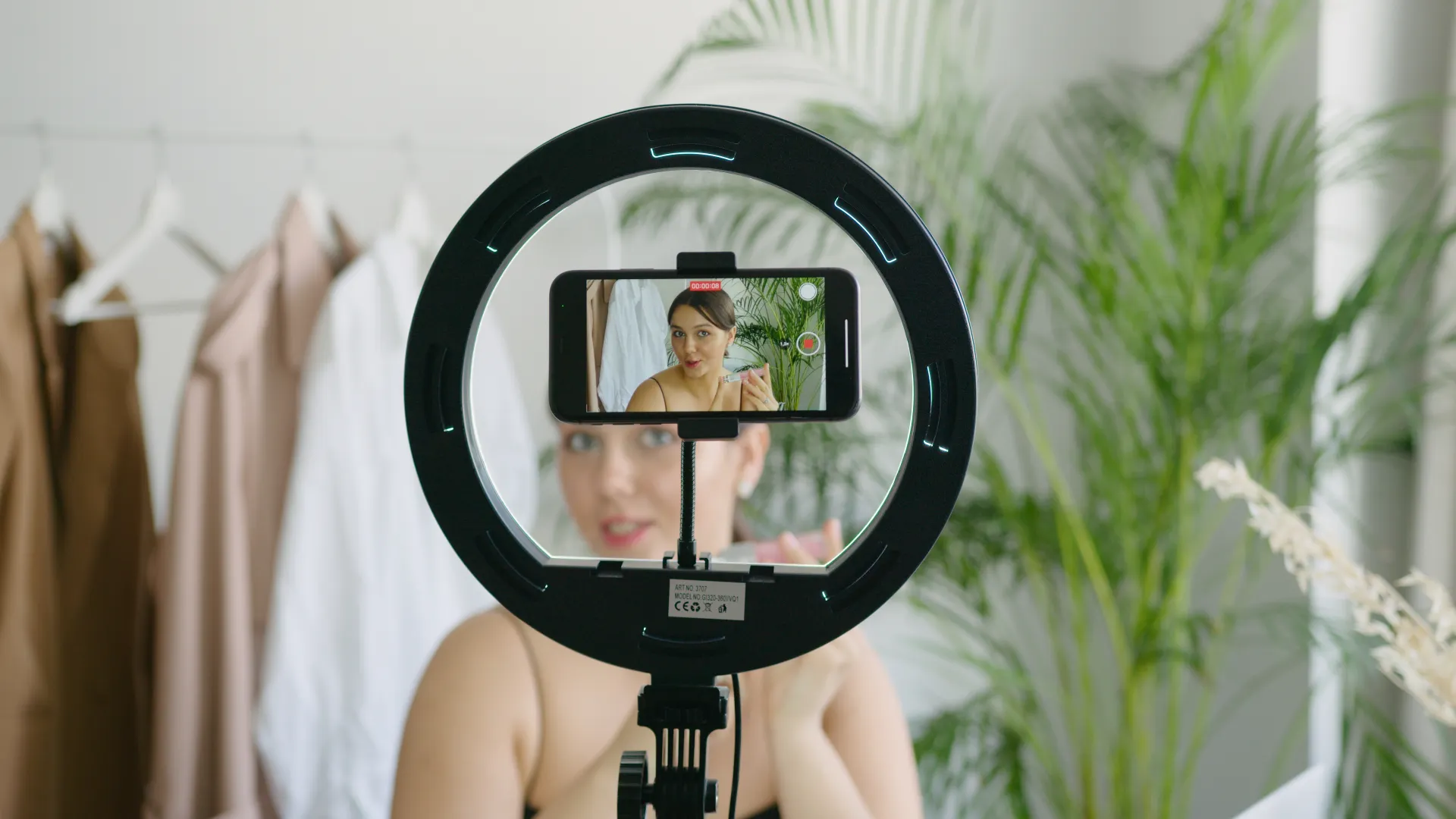 A phone on a ring light filming a piece to camera