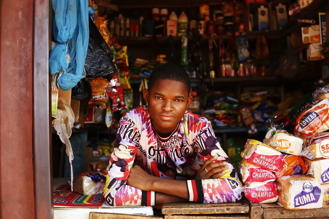 A young shopkeeper at his market stall in Abuja