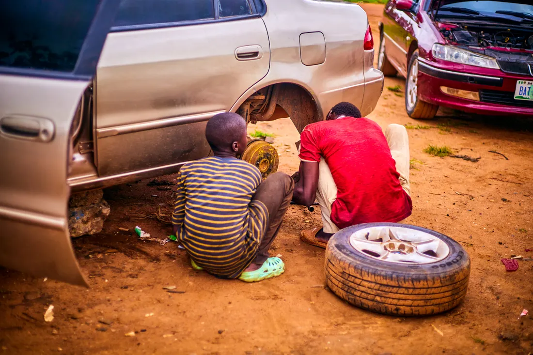Roadside mechanics working on a car in Nigeria
