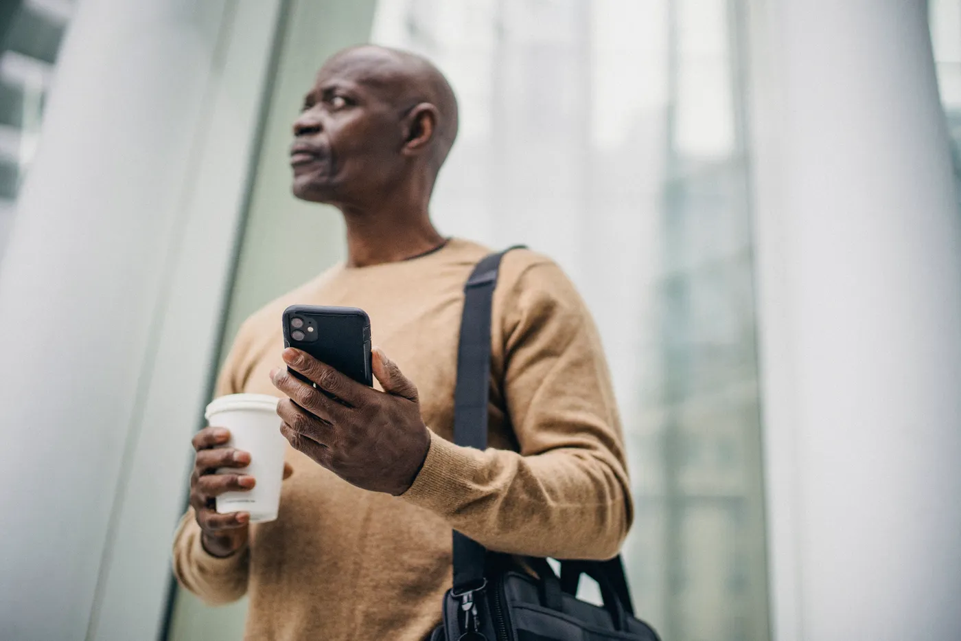 A man checking his phone on a city street