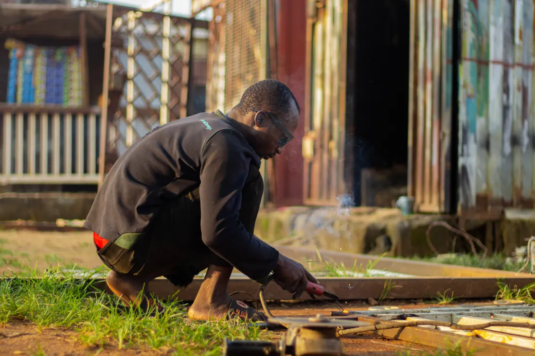 An artisan welding metalwork outdoors
